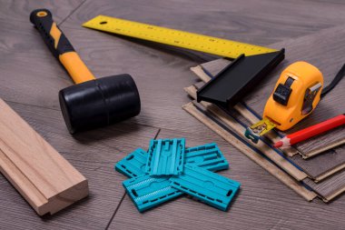 Kauçuk çekiç, uzay boşlukları, kalem, çekiç ve sayaç gibi lamine döşeme ve ekipman parçaları. Seçici odak.