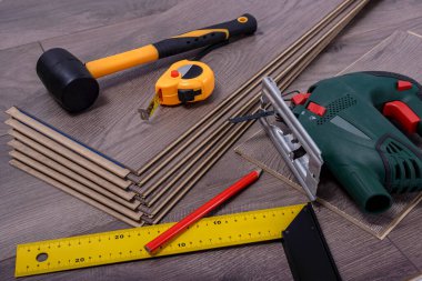 Lastik zemin, plastik çekiç, elektrikli testere, kalem ve metre monte etmek için ekipman ya da aletler. Seçici odak. 