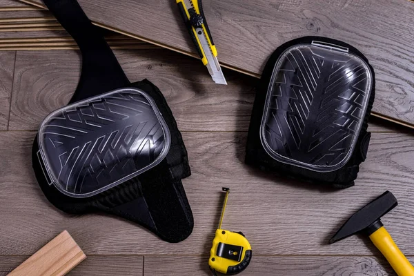 Döşeme ve ekipman levhaları ya da bunları monte etmek için gerekli aletler, çekiç, dizlik, kesme ve metre. Seçici odak.