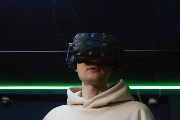Man using virtual reality headset in dark room of vr gaming club. Concept of virtual simulation, gaming, internet of things.