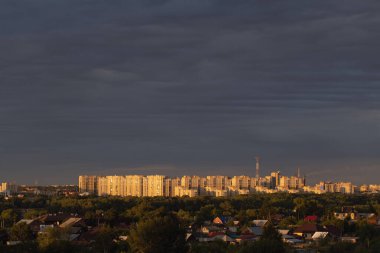 Gökyüzü mavi gökyüzü ve yüksek binaların ve kır evlerinin olduğu bir şehir manzarası. Rusya 'ya git ya da gözlem güvertesinden görüş. Bölgelerin kentleşmesi veya çevre sorunları.