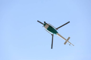 Mavi gökyüzünde uçan video izleme sistemi olan bir helikopter. Spor müsabakalarından video alıyor