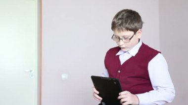 sınıfta masaya oturan tablet oynayan çocuk