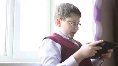 gözlüklü çocuk üzerinde plaka duran pencerede çalış.