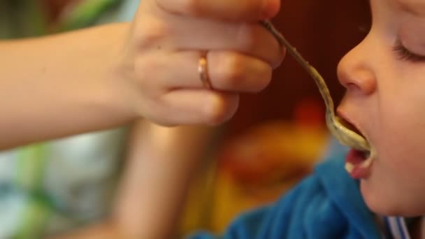 Mãe limpa pano depois de alimentar o mingau de cereal do bebê — Vídeo de Stock