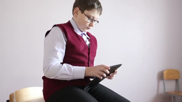 Jongen spelen tablet zitten op het Bureau in de klas — Stockvideo