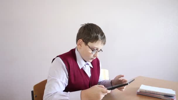 Menino com óculos jogando o tablet na escola — Vídeo de Stock