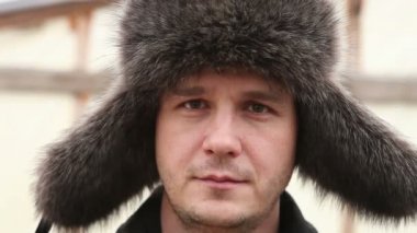 adam kışın kürk şapka görünüyor fotoğraf makinesine ve gülümseyen