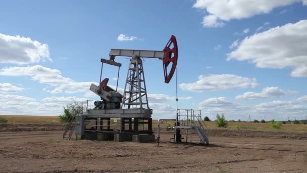 Working oil pump on a background cloudy sky — Stock Video
