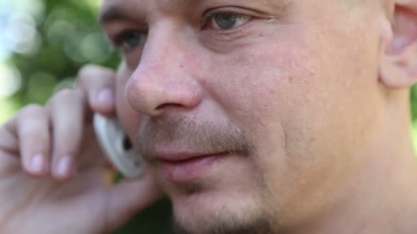 Man aan de telefoon buiten aan het praten — Stockvideo