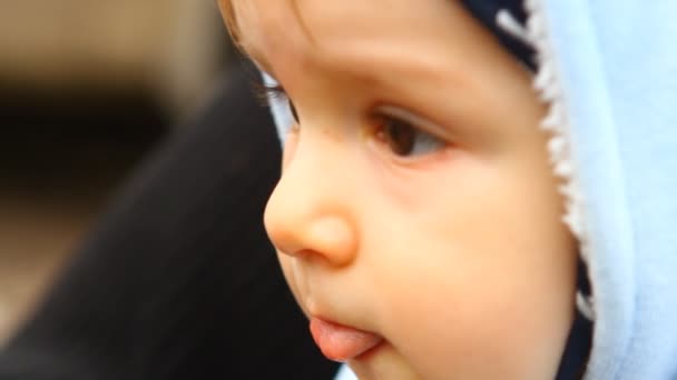 Uma criança triste olha em volta, close-up — Vídeo de Stock
