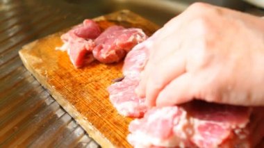 Kadının domuz eti kesme tahtası üzerinde closeup kesip.