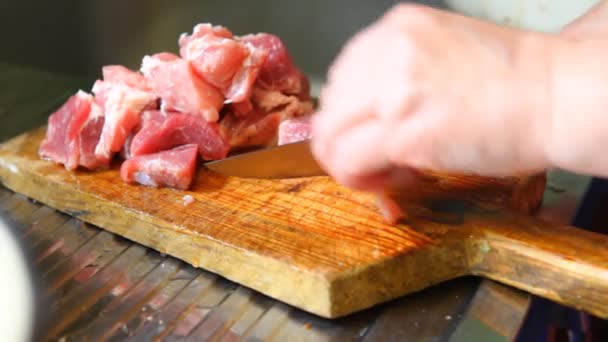 Vrouw gesneden varkensvlees op een snijplank, close-up — Stockvideo
