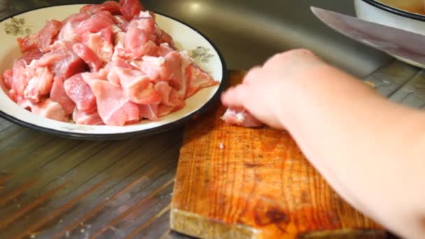 Mujer cortar carne de cerdo en una tabla de cortar, primer plano — Vídeo de stock