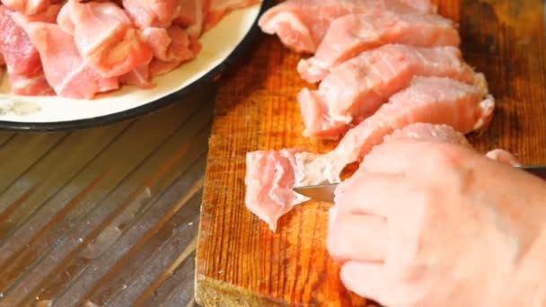 Mujer cortar carne de cerdo en una tabla de cortar, primer plano — Vídeo de stock