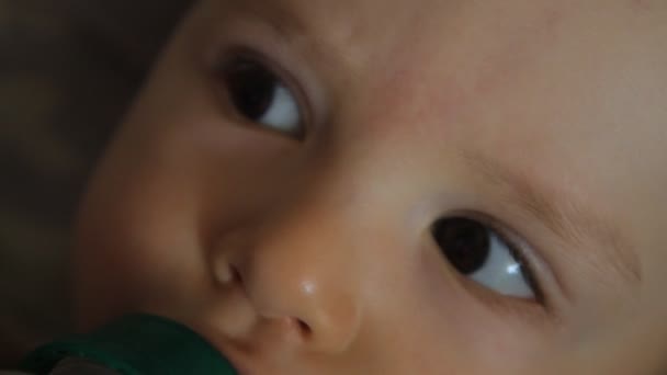 Baby drinks juice from a bottle, close-up portrait — Stock Video