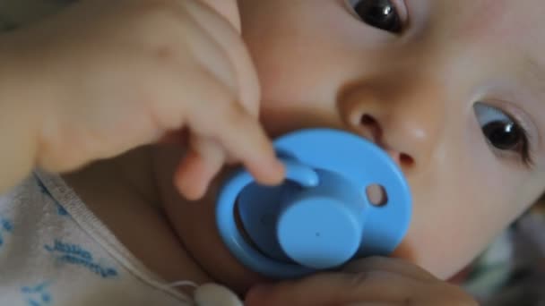 Portrait of baby with blue pacifier — Stock Video