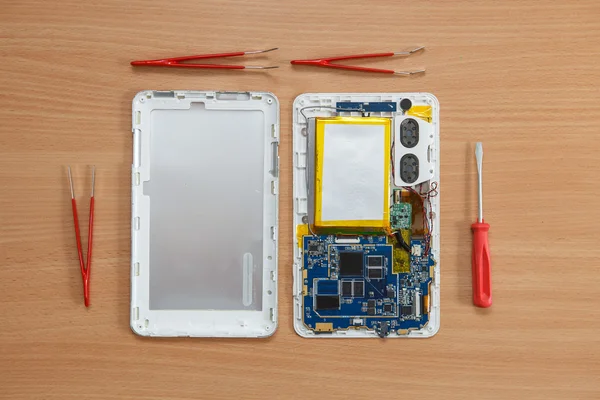 Disassembled tablet and tools on the table. View from above. — Stock Photo, Image