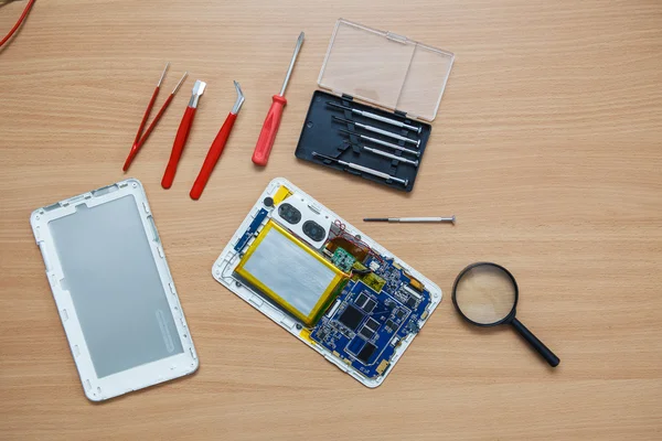 Disassembled tablet and tools on the table. View from above. — Stock Photo, Image