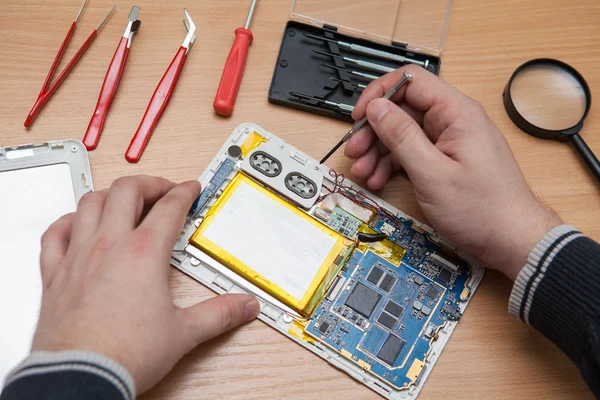 Master Hiermee repareert u de tablet pc. Bovenaanzicht van handen werken. — Stockfoto