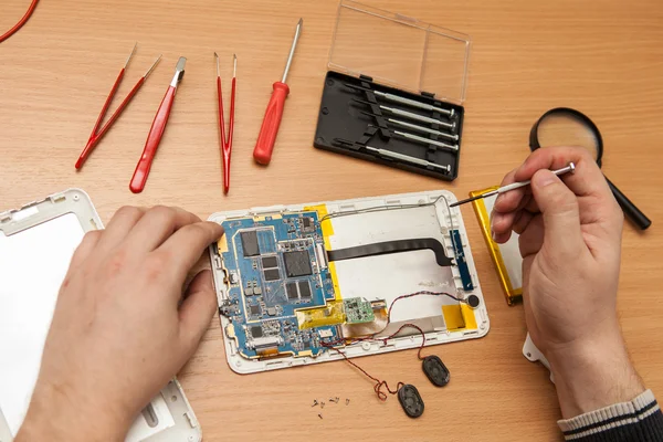 Master Hiermee repareert u de tablet pc. Bovenaanzicht van handen werken. — Stockfoto