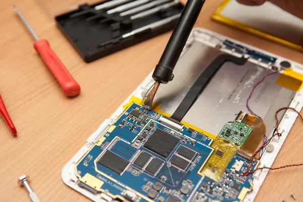 Master solder wires exploded tablet computer. View from above. — Stock Photo, Image