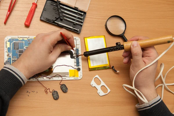 Master solder wires exploded tablet computer. View from above. — Stock Photo, Image