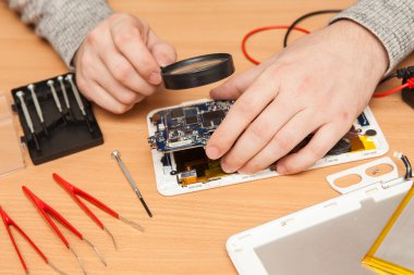 Master bir büyüteç ile ayrıştırılmış plaka inceliyor.