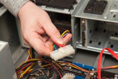 Güç kaynağı kablosunu tutan teknisyen.