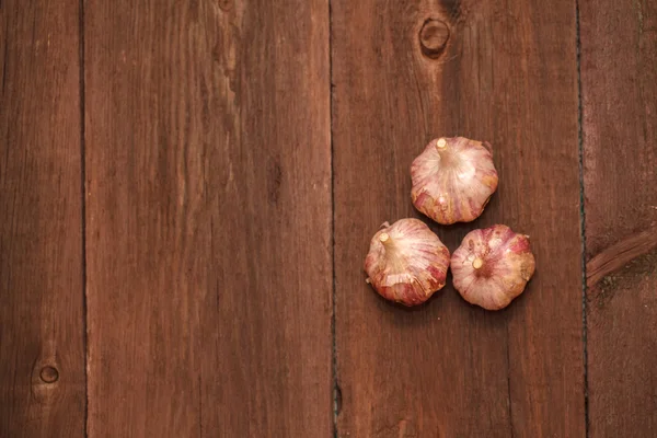 成熟的大蒜的头靠在一个木制的背景 — 图库照片