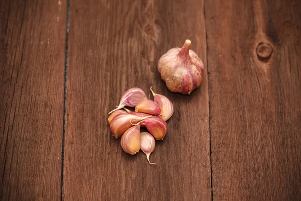 Spicchi d'aglio su uno sfondo di legno — Foto Stock