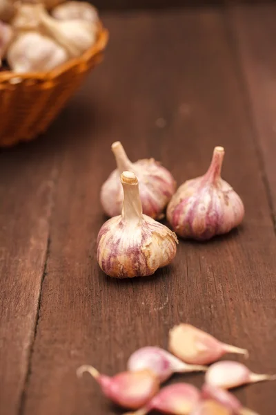 Stroužky česneku na dřevěné pozadí — Stock fotografie