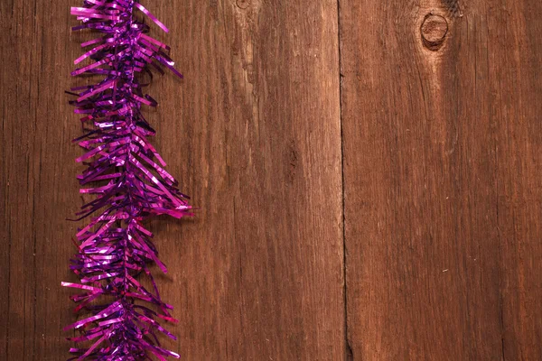 Christmas tinsel on a wooden background — Stock Photo, Image