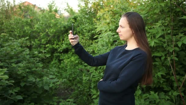 Jovencita haciendo selfie de pie en el parque cerca del árbol — Vídeo de stock