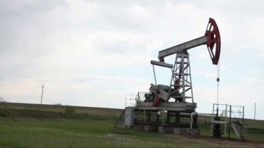 yağ pompası petrol pompalıyor. Bulutlu gökyüzü.
