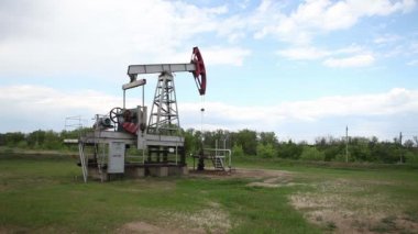 yağ pompası petrol pompalıyor. Bulutlu gökyüzü.