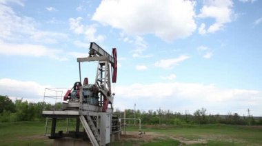 yağ pompası petrol pompalıyor. Bulutlu gökyüzü.