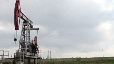 yağ pompası petrol pompalıyor. Bulutlu gökyüzü.