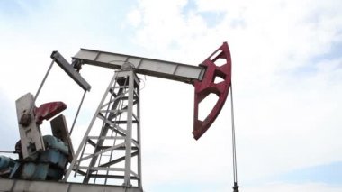 yağ pompası petrol pompalıyor. Bulutlu gökyüzü.