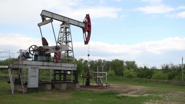 The oil pump is pumping oil. Cloudy sky. — Stock Video