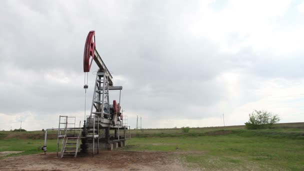 The oil pump is pumping oil. Cloudy sky. — Stock Video