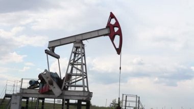 yağ pompası petrol pompalıyor. Bulutlu gökyüzü.