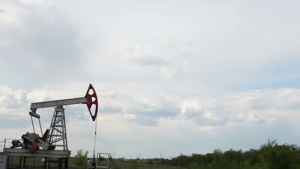 De oliepomp is het pompen van olie. Bewolkte hemel. — Stockvideo