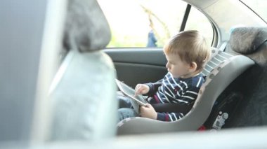 küçük çocuk Oto Koltuğu arabada oturan tablet kullanma