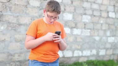 Çocuk bir smartphone bir ileti yazar. Açık havada