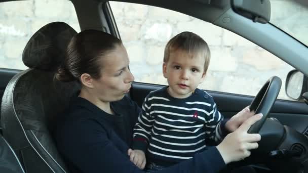 Máma sedí za volantem auta s malým dítětem. — Stock video