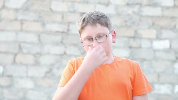 Rapaz com óculos a olhar para a câmara. Ao ar livre — Vídeo de Stock