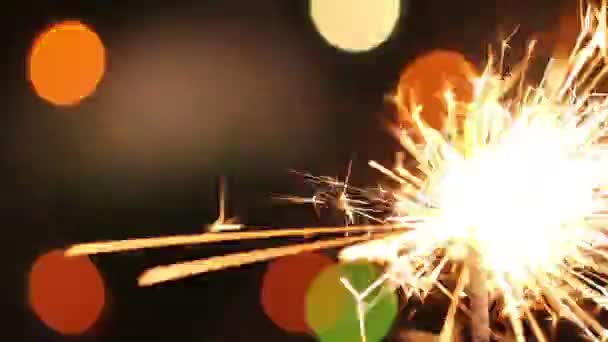 Hořící prskavka na pozadí blikající rozmazané věnec — Stock video