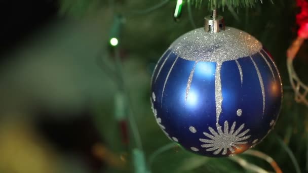 Blaue Kugel mit Girlanden auf einem Weihnachtsbaum — Stockvideo