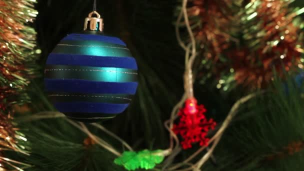 Blaue Kugel mit Girlanden auf einem Weihnachtsbaum — Stockvideo